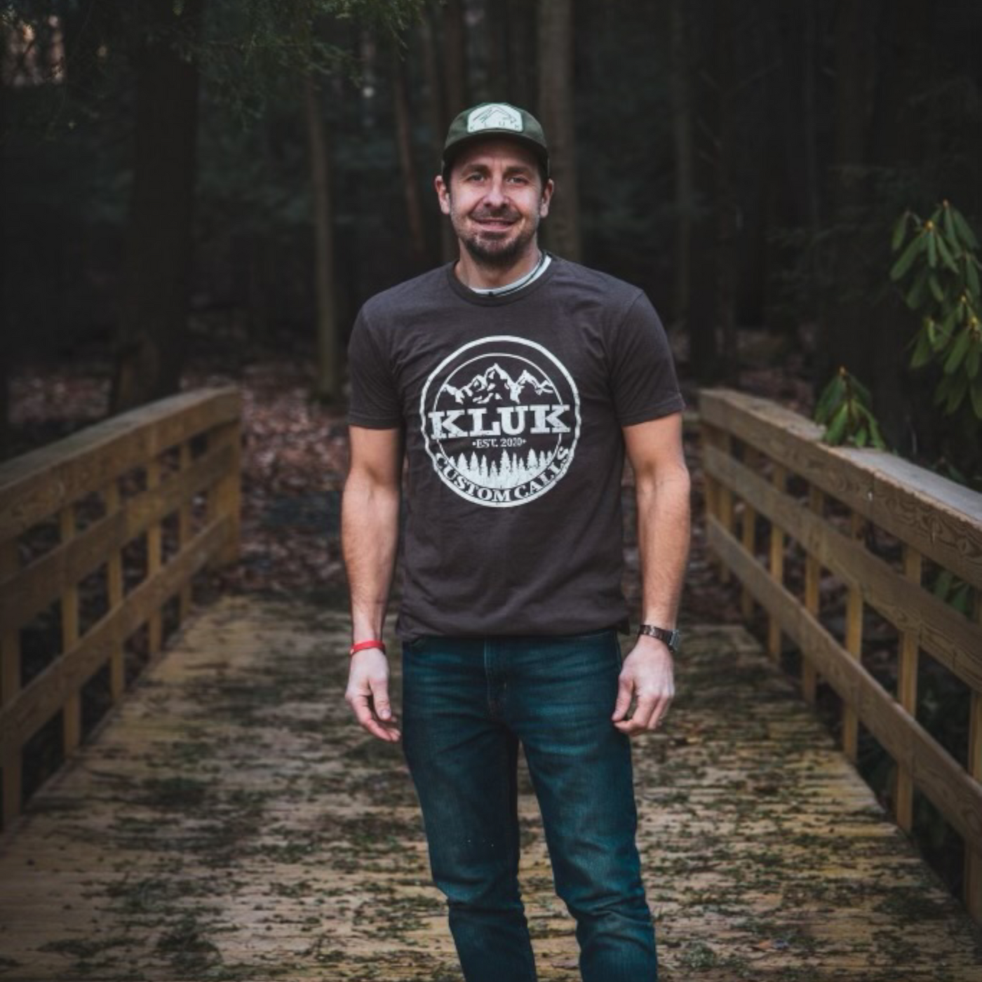 Jed wearing the Espresso colored Logo T-Shirt on a wooden bridge