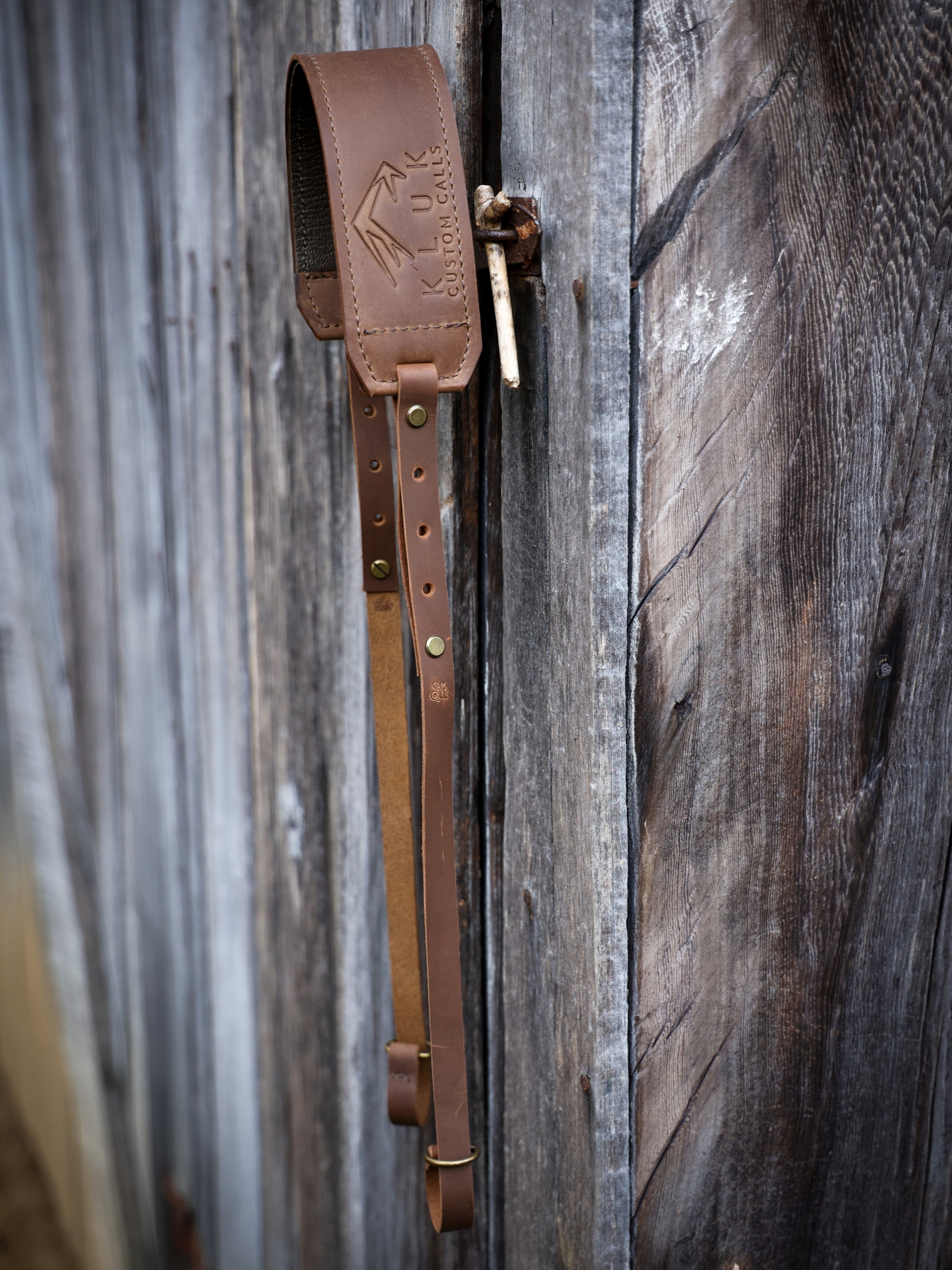 Leather turkey tote product shot hung up against barn door