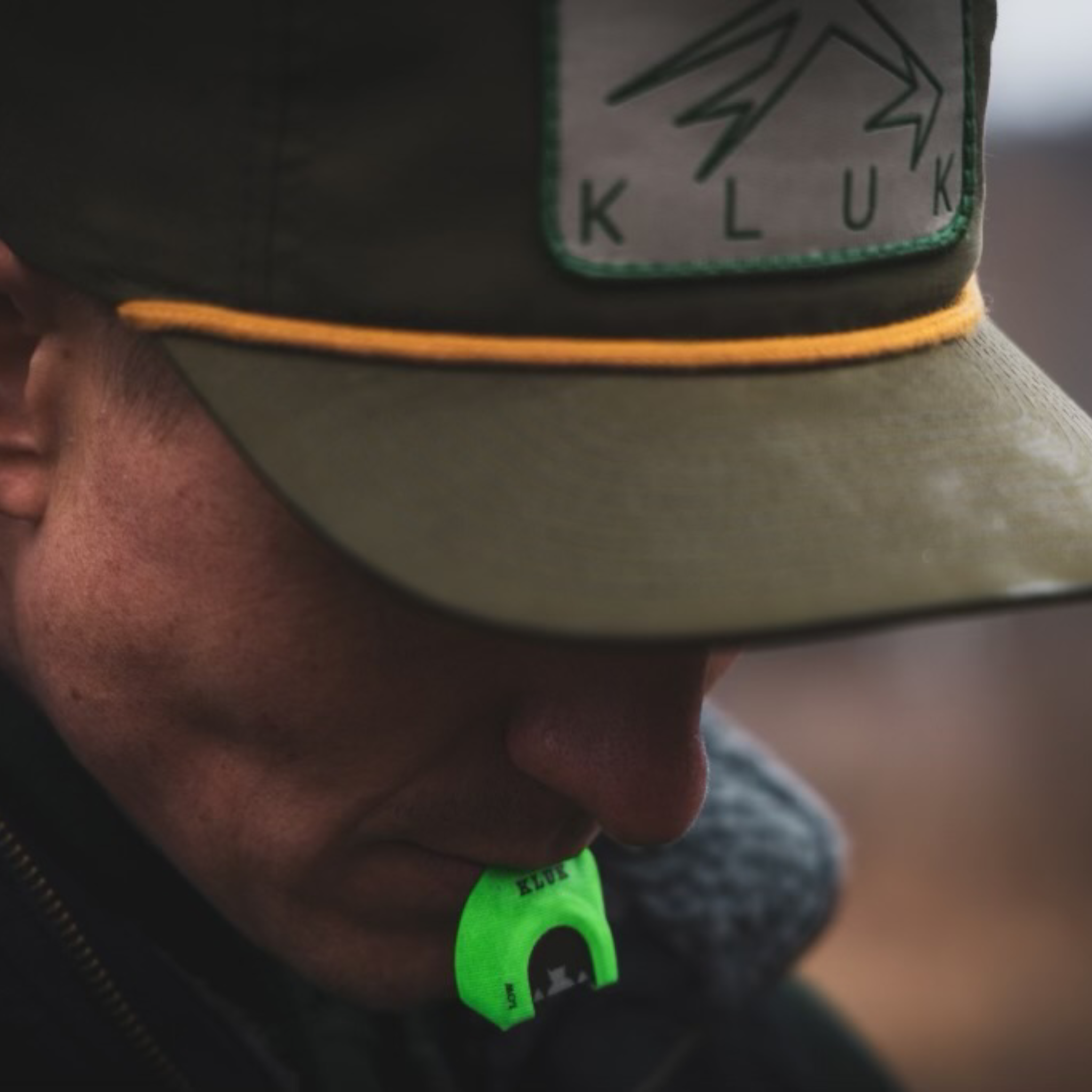 The Loden Gold Pap hat showing the textures of the hat while mouth holding a turkey call