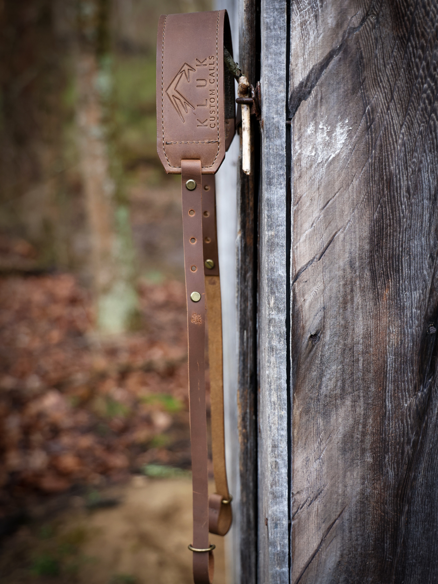 Leather Turkey Tote Product shot hung against a barn door showing the outdoors